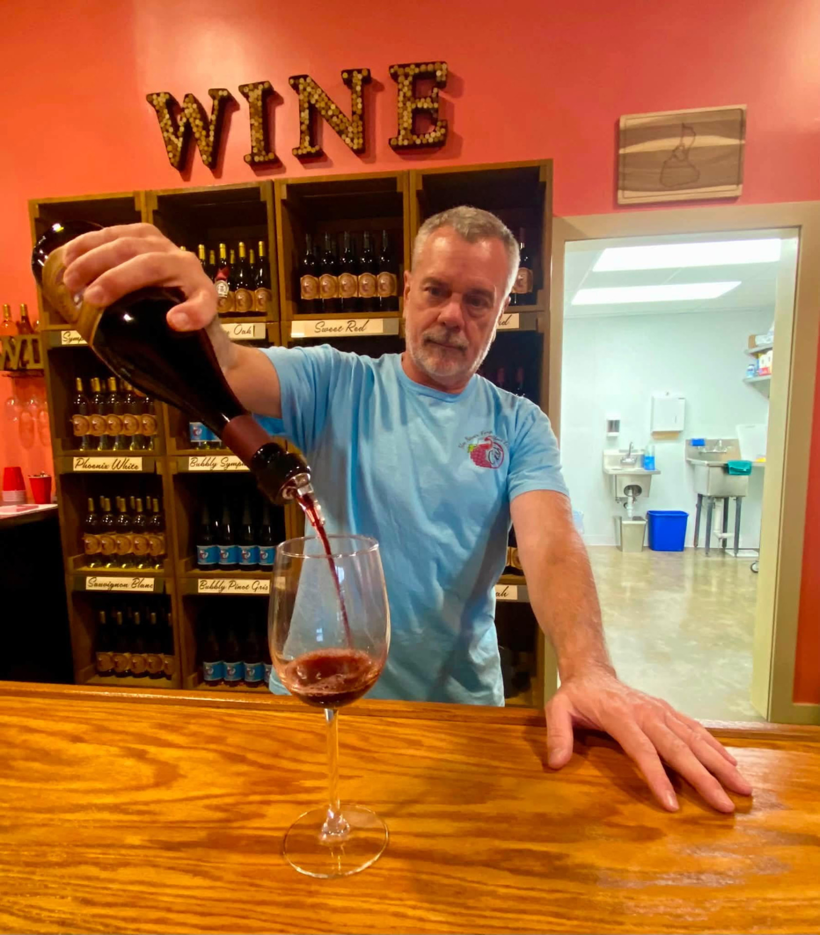 Arnie Schloemann pouring wine at Crush Winery
